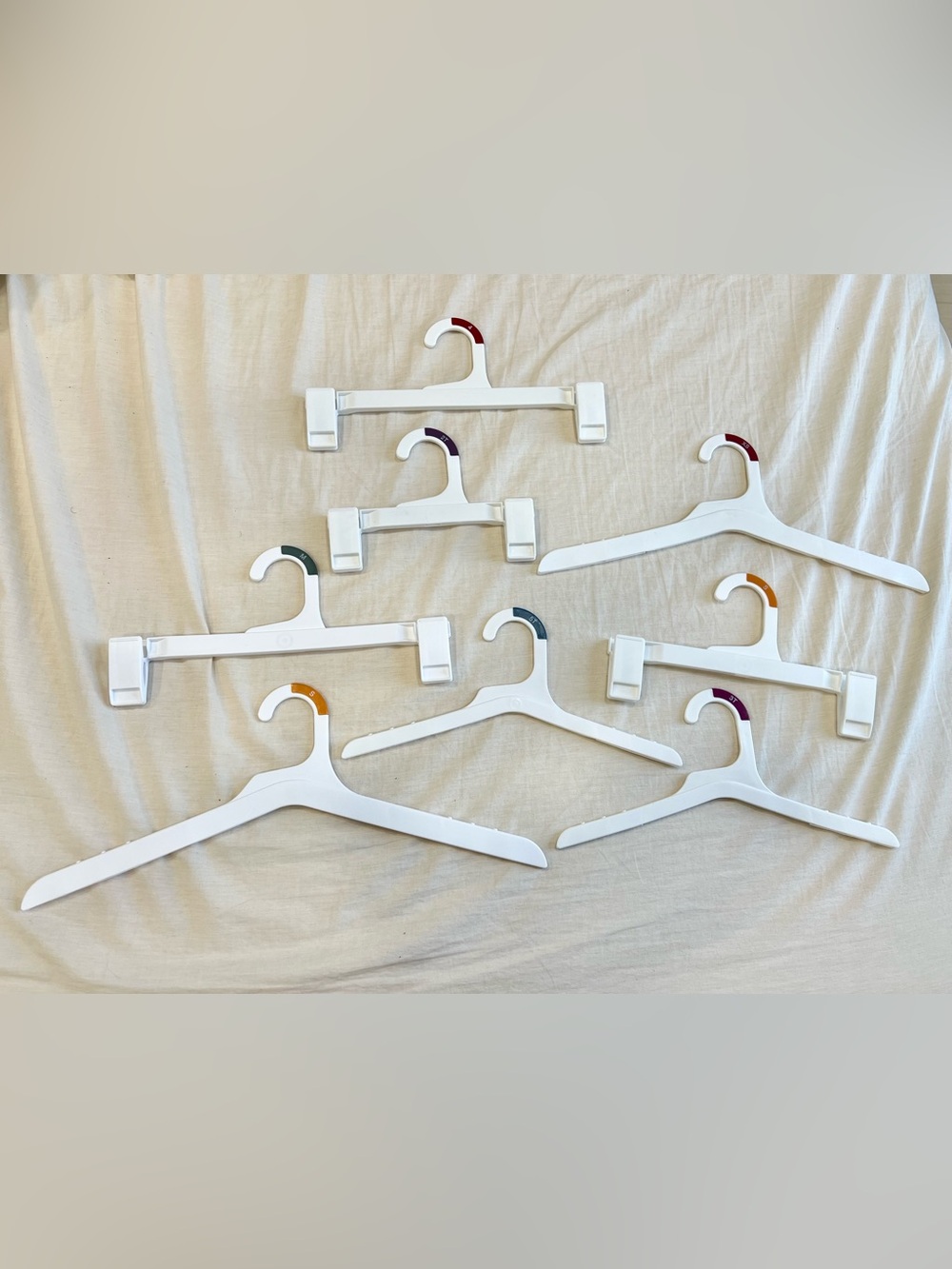 Set of White Plastic Clothing Hangers with Colored Hook Accents
